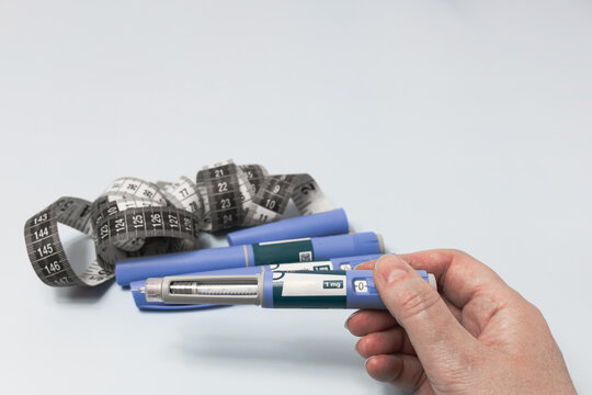 Ozempic injection pen in patient hand for diabetes and obesity treatment.