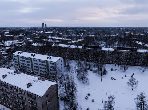 Aerial view of the Agenskalna priedes neighborhood with snow-covered apartment buildings, bare trees, and a park area in winter, Riga, Latvia.