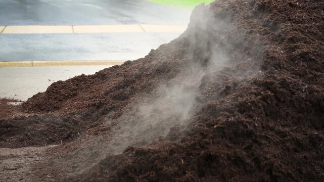 Large pile of fresh mulch in residential neighborhood for landscaping project. Lawn care and garden maintenance service