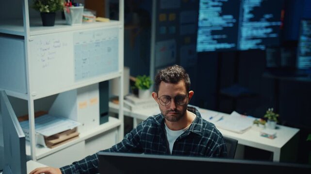 Young Caucasian male programmer write code on computer in home office at late night. AI technology, cybersecurity, software developer, freelance innovation, database system, digital network concept.