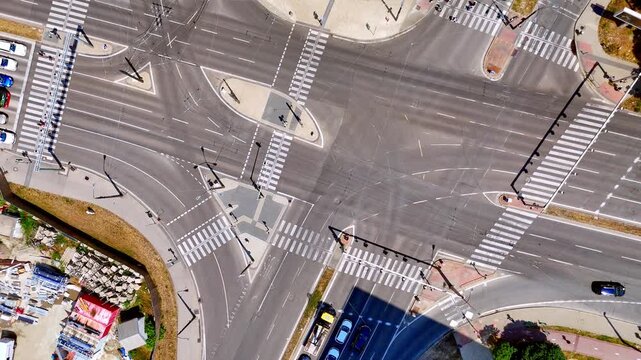 Wide view of asphalt road crosswalks, Bratislava, Slovakia. High angle drone shot of empty pedestrian zebra crossings and traffic islands on a sunny day.