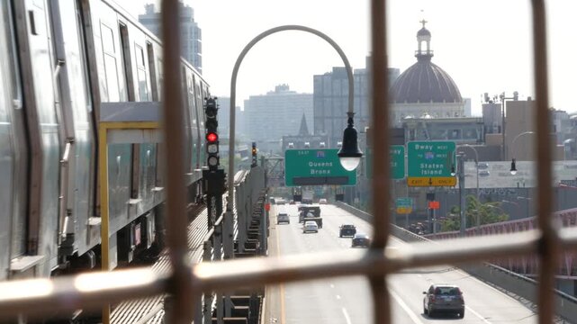 Williamsburg Bridge in Brooklyn, New York City United States. Transport metallic bridge pedestrian path near Marcy Av subway station and Domino park. Queens and Bronx road traffic sign, metro train.