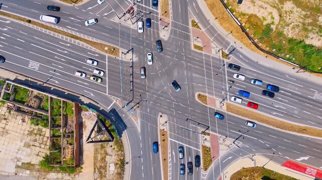 Overhead view of vehicles at an urban junction, Bratislava, Slovakia. Straight down aerial shot of cars crossing white markings on asphalt roads.