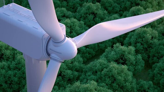 Close up of wind turbine with lush forest in the background. 
