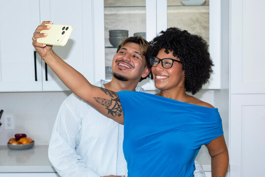 Selfie flash Cell phone Young hispanic couple in Kitchen 