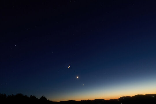Crescent Moon, planet conjunction and landscape scenery silhouettes.