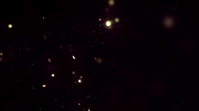 Glowing gold dust particles floating and spinning abstract bokeh background