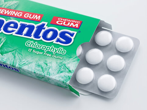 Mentos chlorophyll chewing gum pack and pieces on white surface