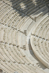 A high angle vertical shot showing the sweeping curved rows of restored white marble seating inside the ancient Odeon of Herodes Atticus in Athens Greece. © nahhan