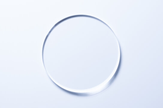 A glass circle on a blue background. A template for placing samples of cosmetics or medical products or food.