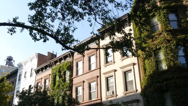New York City townhouse buildings, brownstone row houses in Manhattan or Brooklyn, United States of America. Classic buildings on residential district street. Real estate property. Rowhouse townhome.