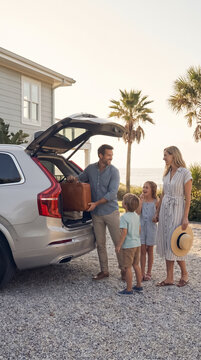 Loving family standing near their packed SUV car trunk