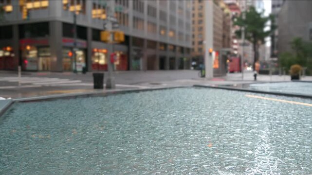 Manhattan Midtown East 53 street, New York City, United States. Yellow taxi car, Lexington avenue road traffic. Rainy day weather, drops on pavement, wet sidewalk in central business district. morning