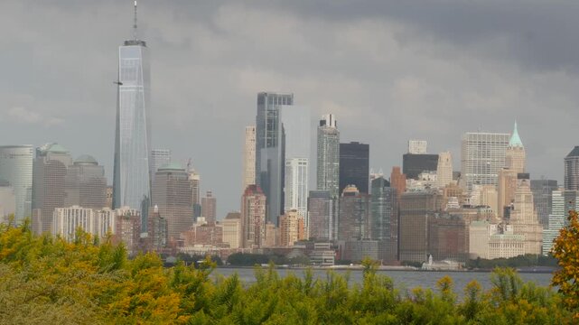 New York City Manhattan Downtown skyline from Liberty Island, United States. Financial District cityscape, World Trade Center skyscraper tower. Building architecture. Rainy cloudy autumn fall weather.