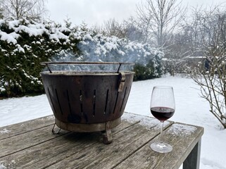 Fototapeta premium Outdoor winter barbecue with a glass of red wine on a snowy day
