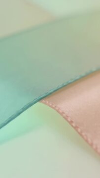 Vertical video: Moving camera refocusing over teal strip on pale surface, revealing pink strip seam