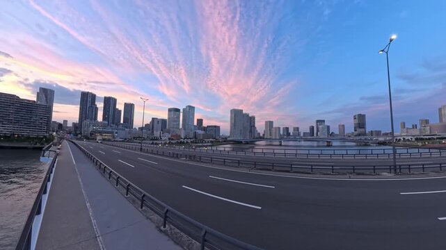 TOKYO, JAPAN - JUNE 2026 : High angle tracking shot of luxury skyscraper apartments and modern waterfront in Toyosu area. Real estate and metropolitan living concept video. Sunset time lapse shot.