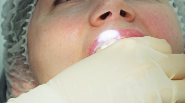 A close-up of a dentist screwing the first titanium part of a dental implant into a patient's jaw with a driver