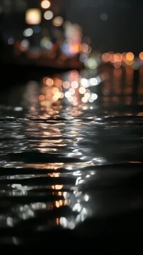 Night city lights reflect beautifully on the rippling water surface, creating a dreamy and abstract bokeh effect. Urban atmosphere and vibrant energy blend in this mesmerizing scene