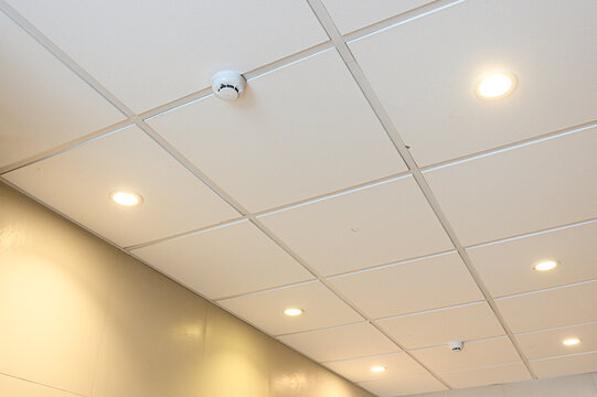 ceiling features white square tiles with recessed lighting and smoke detector. beige wall complements clean, functional interior