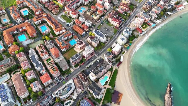 Aerial view of a coastal resort town. Top-down view of a seaside city with hotels and residential complexes. View of the Black Sea.