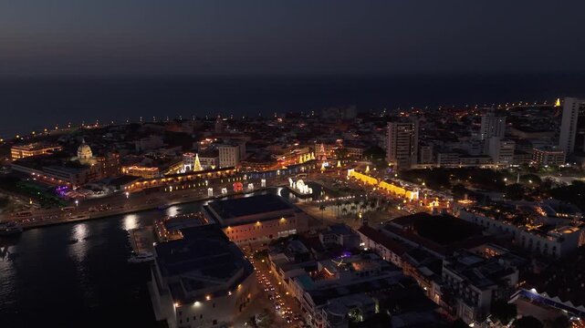 Centro hist&oacute;rico de Cartagena iluminado durante la noche con vista a&eacute;rea del puerto