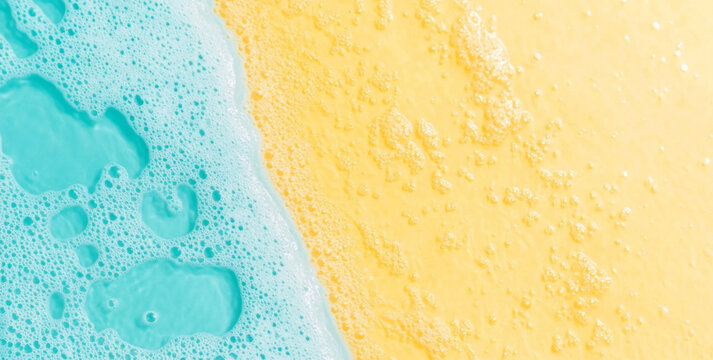 Close-up of blue detergent foam on yellow background, ideal for creative projects