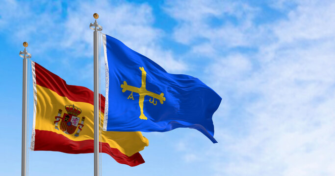 The Asturias flag waving with Spanish flag on a clear day