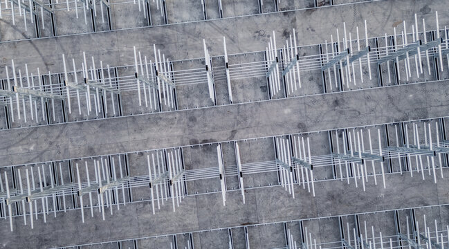 Aerial view of a multi-level vehicle storage structure with rows of metal frames on a concrete surface Livron-sur-Drome, Auvergne-Rhone-Alpes, France.