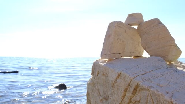 Calm sea, tranquil ethereal view. Stones, cliff. Empty template for text. Harmony, mental health concept. Dreamy scenery. Pure water with reflections sunlight, Smooth, weathered stones along the shore