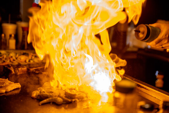 Hibachi chef spraying sake on the meat