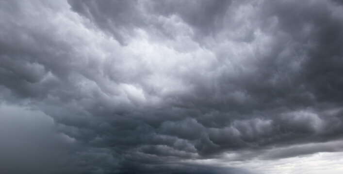 Dramatic dark grey storm clouds gathering in the sky creating an ominous and moody atmosphere before heavy rainfall and extreme weather conditions.