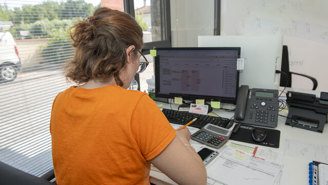 Administrative secretary managing tasks and emails on computer with concentration