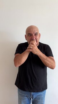 C&aacute;mara lenta de hombre latino de 50 a&ntilde;os con gesto de rabia mordiendo pu&ntilde;o
