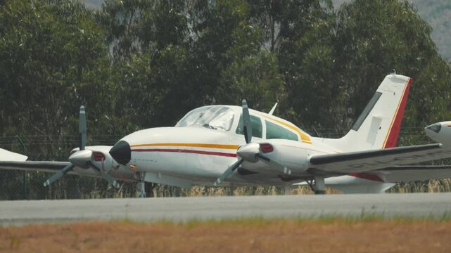 Twin-engine propeller airplane taxiing on runway