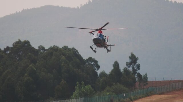 Rescue helicopter landing in mountainous forest area