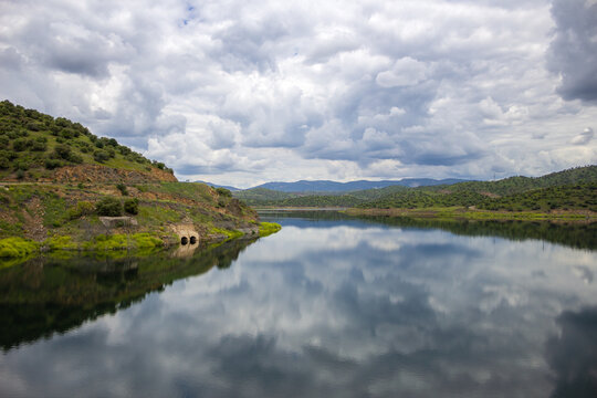 Vista general de un pantano con cielo nubloso reflejado en el agua