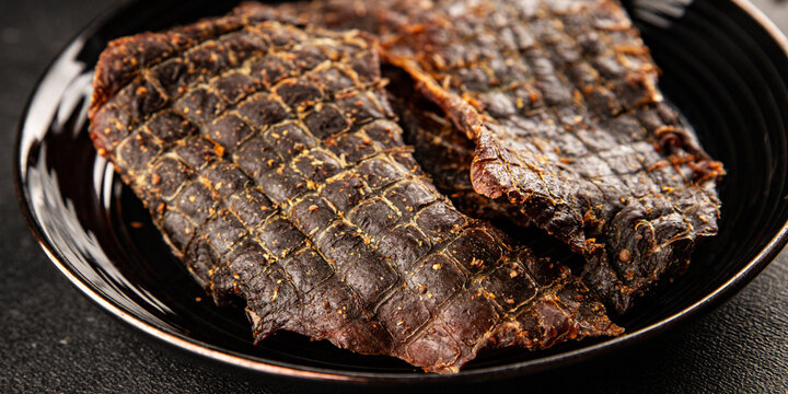 Beef jerky spiced dried meat natural healthy food tasty snack fresh delicious gourmet food background on the table, rustic food, top view, copy space
