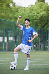Obraz premium Confident young soccer player celebrating on outdoor football field