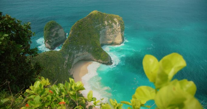 Iconic T Rex shaped rock formation stands tall above ocean at Kelingking Beach Bali Nusa Penida