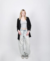 Obraz premium Junge Frau in lässigem Freizeitoutfit vor hellem Hintergrund. Modernes Lifestyle-Motiv für Jugend, Casual Fashion, Selbstbewusstsein, Generation Z und authentische Alltagsmode.