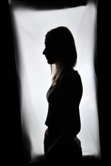 Obraz premium Silhouette einer Frau vor hellem Hintergrund. Ausdrucksstarkes People-Motiv für Identität, Selbstreflexion, mentale Gesundheit, Achtsamkeit, Persönlichkeit und innere Stärke.