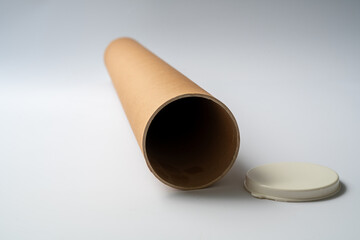 Single cardboard mailing tube standing upright on a clean neutral background, commonly used for shipping posters, documents, blueprints, and protective packaging. © aselight
