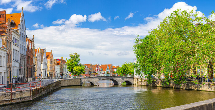 Brugge old town panoramic view, Langerei water canal of Reie river with Carmelite Bridge, medieval houses and green trees on embankment, Panorama of Bruges city historical centre cityscape, Belgium