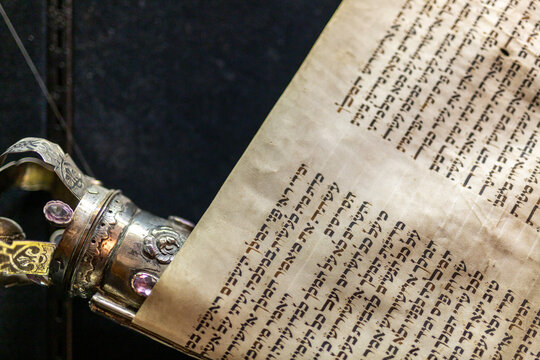 Torah scroll megillat esther with ornate silver scroll handles in synagogue