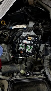 Car electronic control unit circuit board mounted inside engine bay.