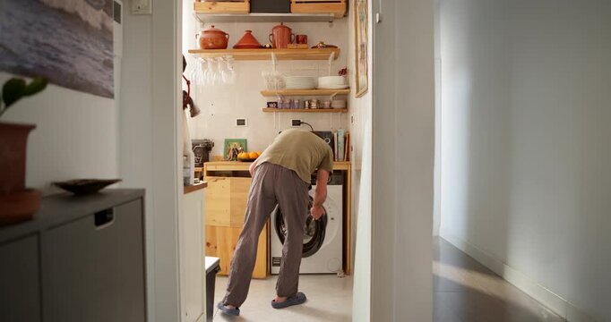 Man Loading Washing Machine in Kitchen Area