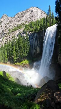 Beautiful view of Vernal Fall waterfall in Yosemite National Park, California, featuring rushing water, granite cliffs, forest scenery, and pristine wilderness landscapes
