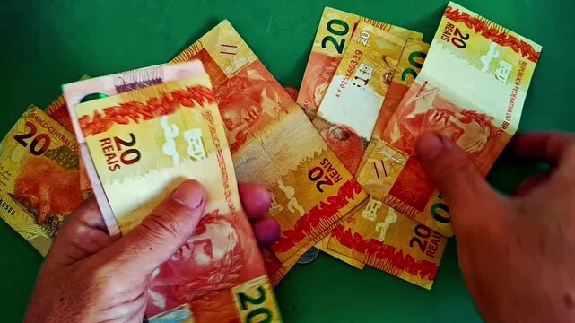 Hands counting brazilian real banknotes in motion video clip footage