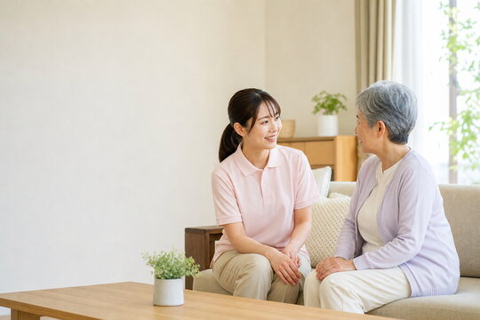 余白のある居間で介護スタッフと話す高齢者
